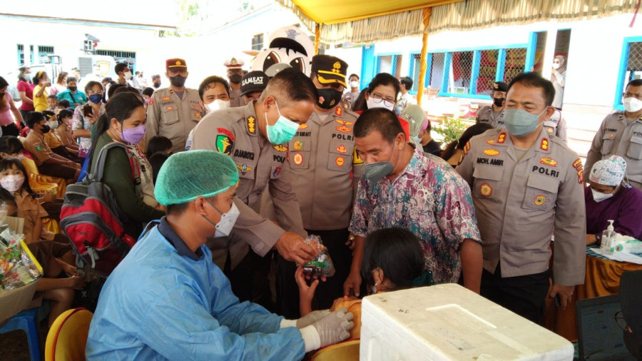 Kasubid Dokkes Polda Kaltim, Kombes Pol dr. Djarot Wibowo saat memberikan bingkisan kepada peserta vaksin dalam rangka memantau pelaksanaan Samsat Kaltim Peduli Vaksin yang berlangsung pada Sabtu (22/1/2022) di Kabupaten Kubar. (Handayan/korankaltim.com)