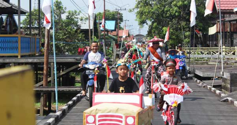 MERIAH: Pawai sepeda saat pembukaan Festival Kampung Tellihan di Muara Muntai. Ribuan warga antusiasi menyambut festival perdana ini. ( reza / koran kaltim )