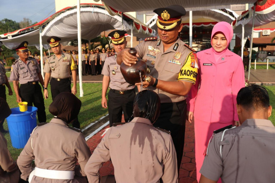 Kapolres Kukar AKBP Anwar Haidar menyiramkan air bunga kepada beberapa anggota sebagai ritual kenaikan pangkat di halaman Polres Kukar, Senin (1/7/2019)