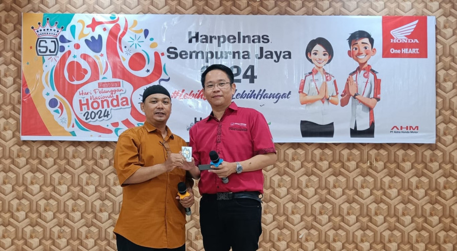 Owner Sempurna Jaya Herman Prabowo memberikan hadiah logam mulia kepada salah seorang pelanggan setia motor Honda. (Istimewa)
