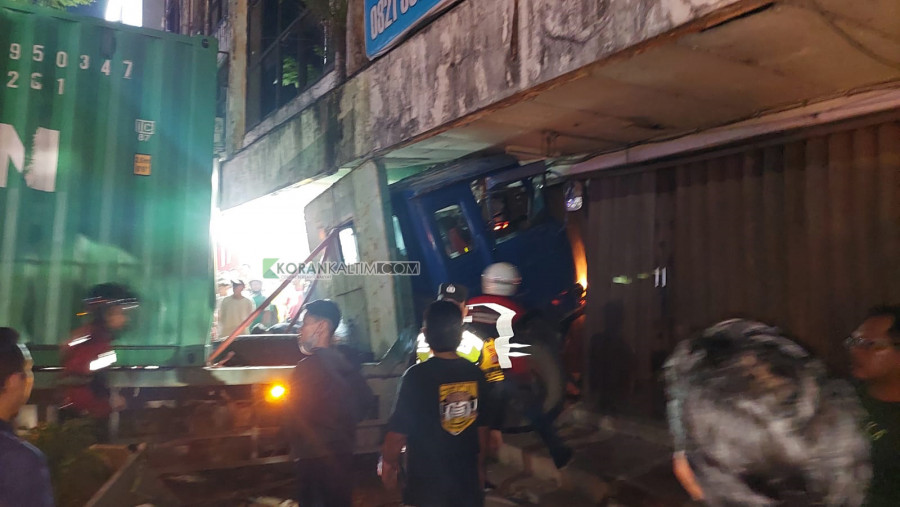 Truk kontainer KT 8846 AJ menabrak satu pengemudi sepeda motor dan bangunan ruko dikawasan Simpang Muara Rapak, Rabu (24/5) malam. (Foto: David Purba/ Korankaltim.com)