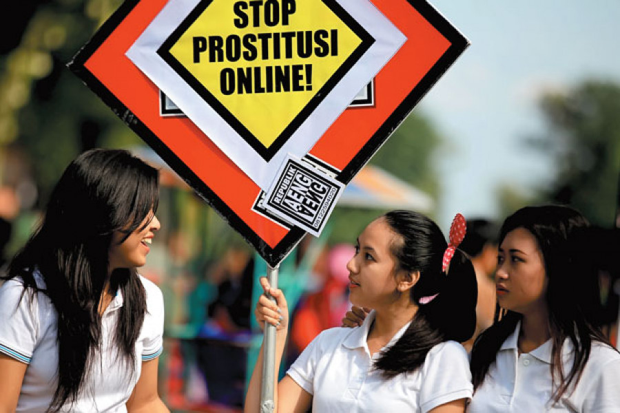 Sejumlah wanita membawa spanduk bertuliskan Stop Prostitusi Online saat menggelar aksi menolak prostitusi online ( Foto: SIndonews)