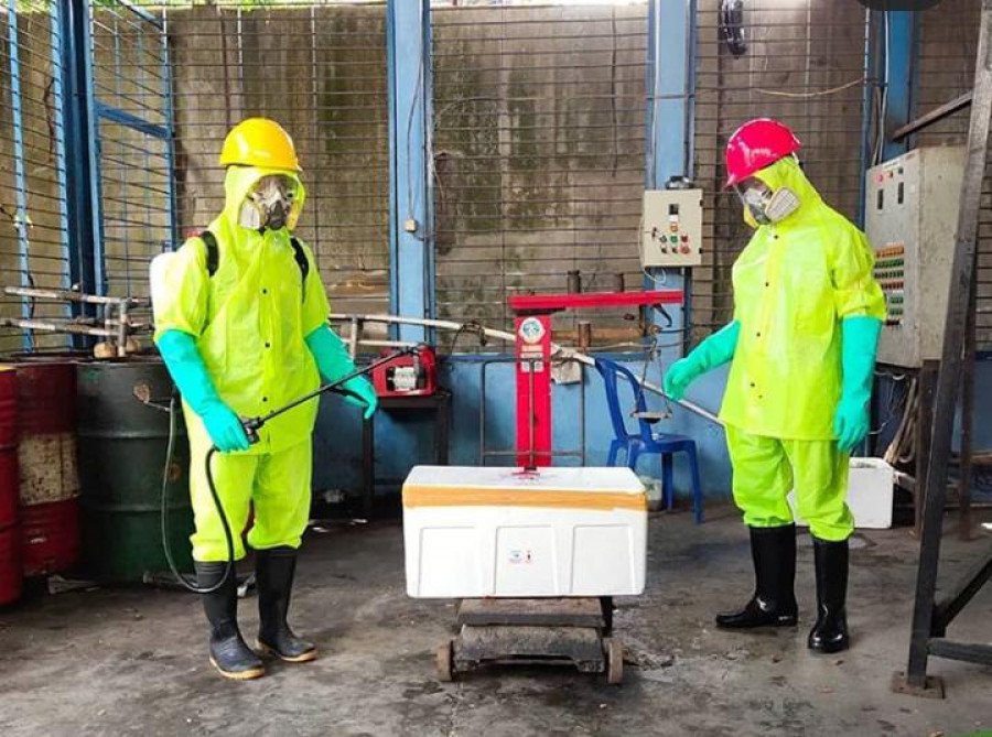 Petugas insenerator, melakukan penimbangan dan penyemprotan disinfektan pada material limbah medis, sebelum dilakukan proses pembakaran. (Dokumentasi DLH Kaltim)