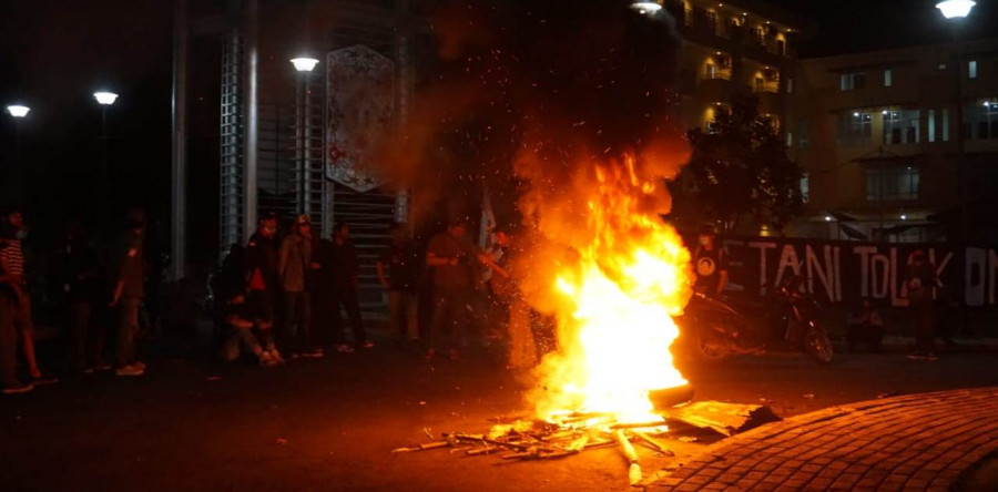 Massa aksi yang melanjutkan orasi mereka di depan gerbang Unmul, pasca dibubar paksa sekelompok orang.(Foto: Nancy/korankaltim.com)