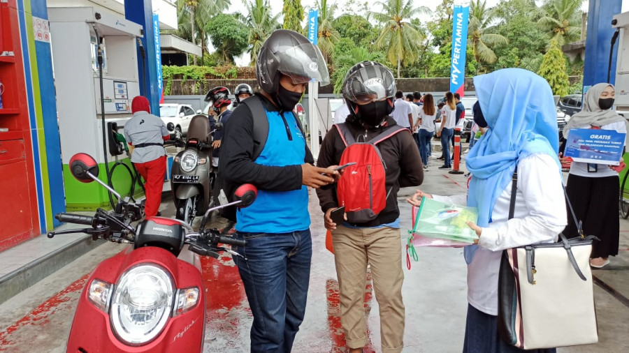 Pengendara diberi perangkat protokol kesehatan saat mengisi BBM di SPBU Coco Jalan MT Haryono Balikpapan. (Foto: Hendra/KoranKaltim.Com)