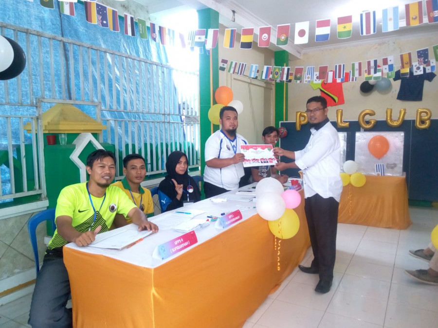 Petugas KPPS menyerahkan surat suara kepada salah seorang warga yang hendak menyalurkan hak pilihnya. TPS ini bernuansa piala dunia. VIAN/KORANKALTIM.COM