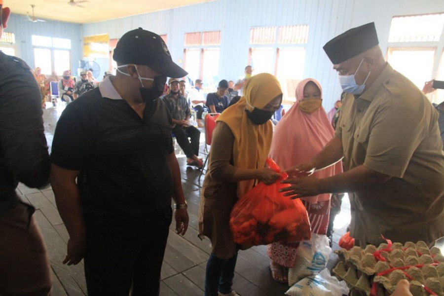 Edi Damansyah saat menyerahkan paket sembako kepada warga di Desa Muara Kaman Ulu. (Foto:IST)