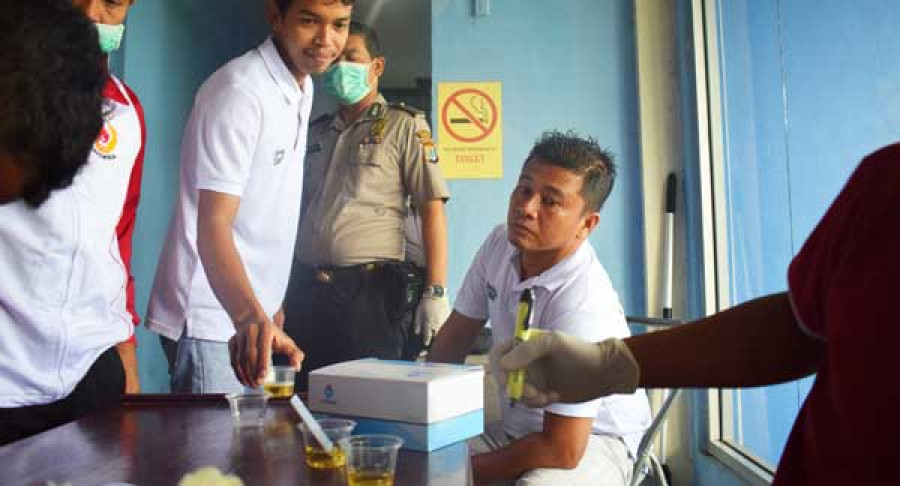 PERIKSA : Salah seorang motoris menyerahkan urine miliknya untuk dilakukan tes narkoba.
