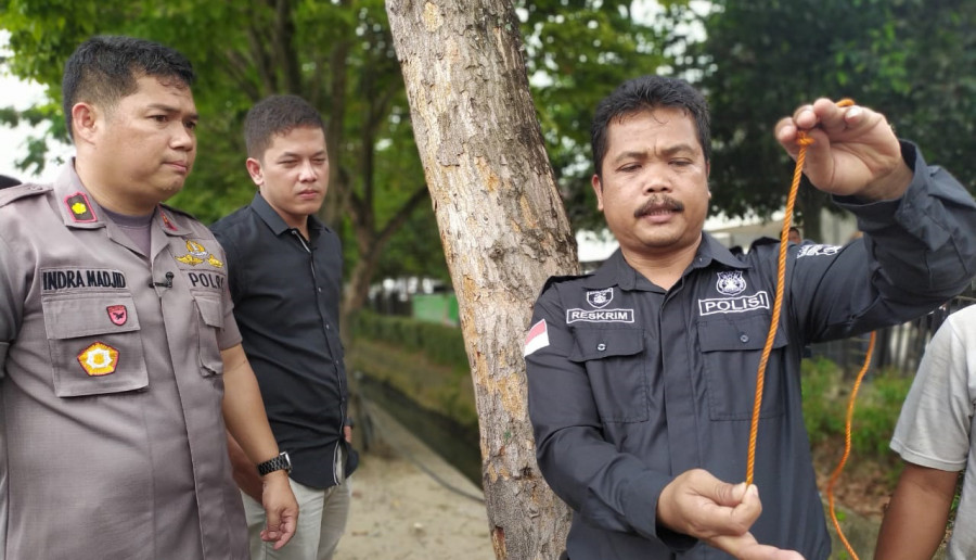 Kanit Reskrim Polsek Samarinda Ulu, Ipda M Ridwan (kanan) saat menunjukkan tinggi celah paret dari teralis besi, yang dugaan korban terperosok dengan parit. (Foto: Nancy/korankaltimcom)