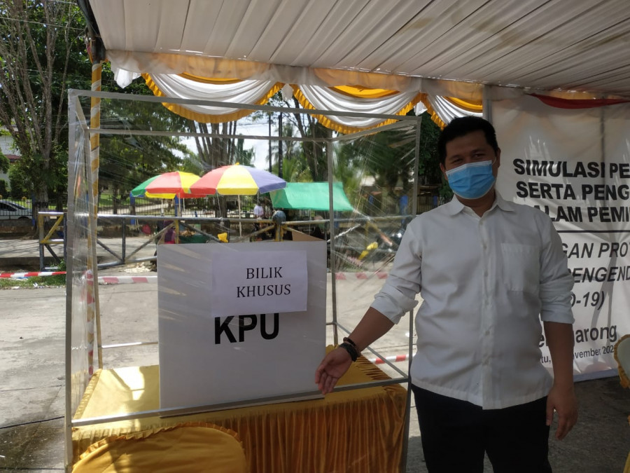 Ketua KPU Kukar, Erlyando Saputra saat memperlihatkan bilik khusus untuk pemilih yang suhu tubuhnya 37,3 persen. Foto:sabri/korankaltim.com)