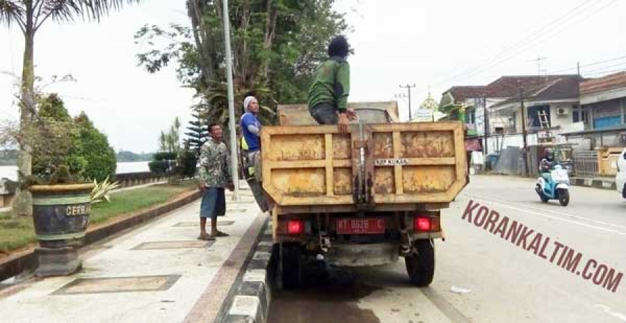 ANGKUT SAMPAH : Pasukan kuning langsung beraksi membersihkan sampah sisa Erau di jalan raya. ( heri / korankaltim )