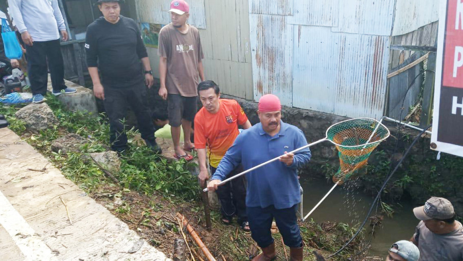 Bupati Kukar Edi Damansyah saat membantu membersihkan drainase yang tersumbat sampah kayu di Jln Ahmad Dahlan pada Gotong Royong Massal, Jumat (14/7/2019