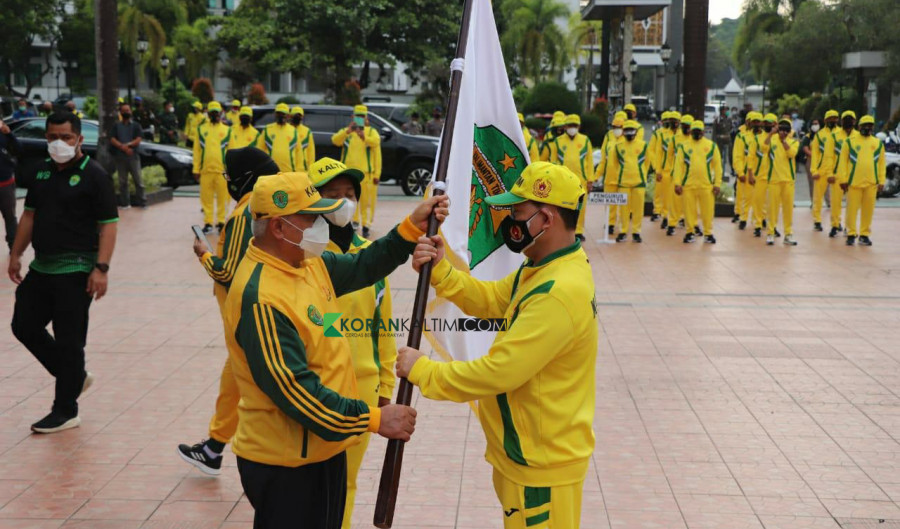 Gubernur Kaltim Isran Noor (kiri) saat menyerahkan bendera pataka sebagai simbol perjuangan, Kontingen Kaltim di PON XX di Papua, kepada Ketua KONI Kaltim Zuhdi Yahya Jumat (24/9/2021) hari ini. (Foto: Nancy/korankaltim.com)
