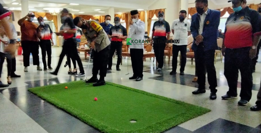 Kapolres Kukar saat mencoba mempraktekkan bermain golf yang baik dan akurat kepada para tamu undangan di pelantikan PGI Kukar (Foto: Heri/korankaltim.com)