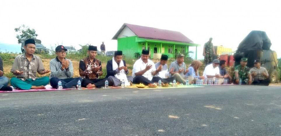 Warga Desa Suka Bumi, Kecamatan Kota Bangun dan Bupati Kukar Edi Damansyah menengadahkan tangan sembari berdoa di desa Suka Bumi belum lama ini. ( Foto: Istimewa/HMS)