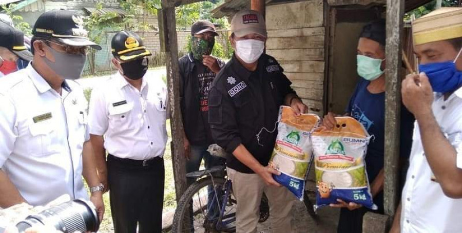 Sekda Kukar Sunggono Serahkan bantuan pangan pokok kepada warga terdampak di Sangasanga. (Foto: HMS)