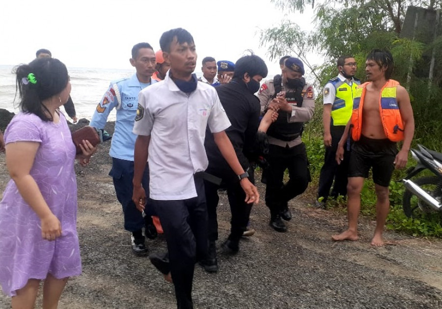 Petugas bersama warga saat evakuasi korban terseret ombak di pesisir pantai belakang Bandara SAMS Sepinggan Balikpapan, Senin (25/7/2022) pagi. (Foto: Istimewa)
