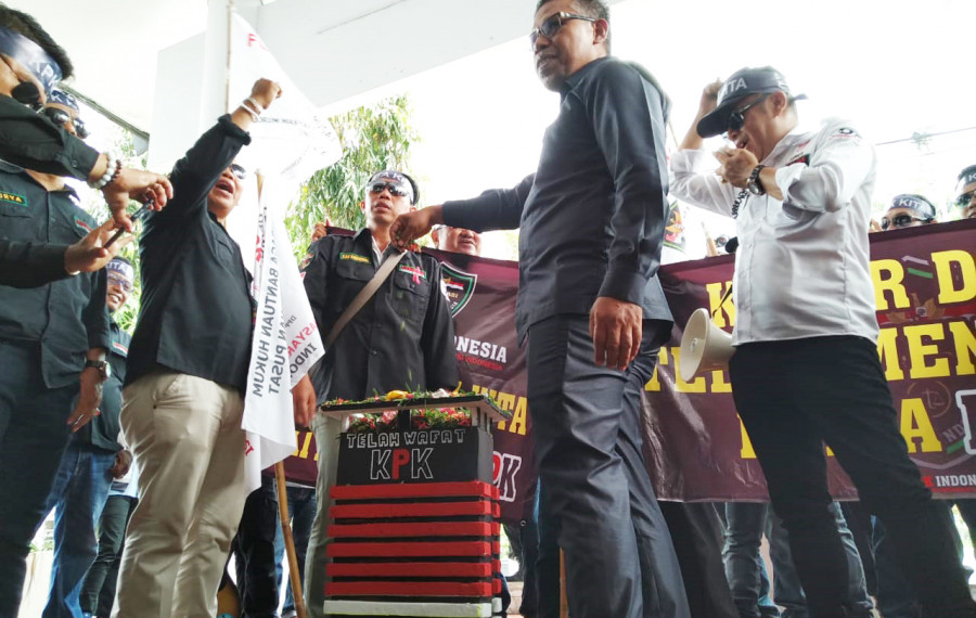 Wakil Ketua DPRD Balikpapan Subari menaburkan kembang ke atas miniatur gedung KPK yang dibawa oleh massa dari Formak. (Hendra/KoranKaltim.Com)