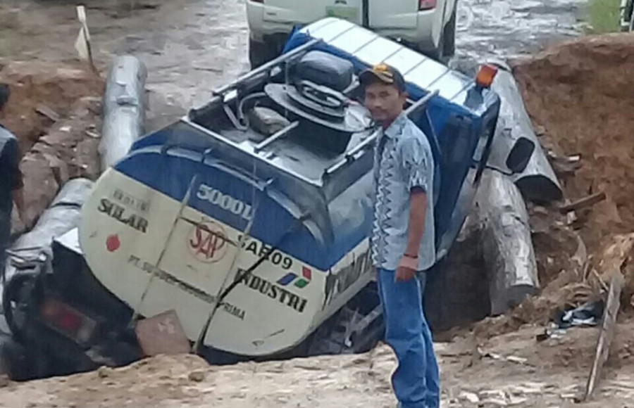 NYUNGSEP:Mobil pertamina nyungsep ke dalam longsoran, di jalan penghubung desa Benoq dan Himba Lestari, Batu Ampar. ( istimewa)