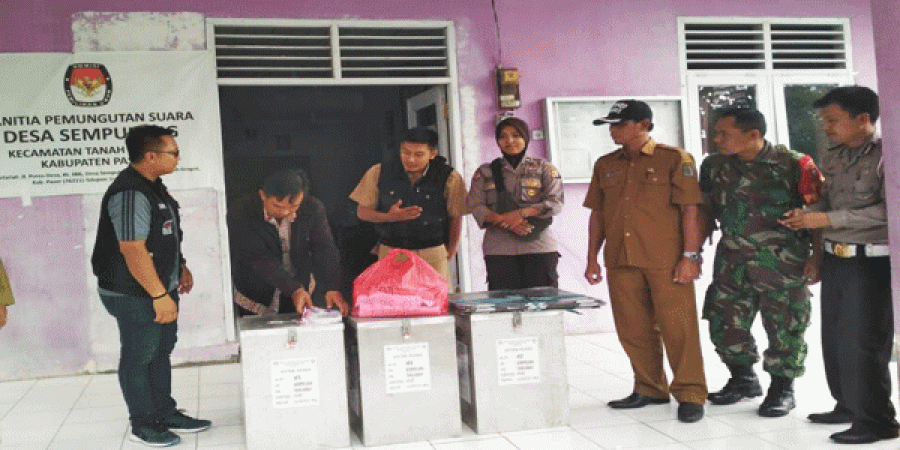 Ketua PPS Desa Sempulang Eko saat menandatangani berita acara penyerahan logistik Pilgub Kaltim. Sebagai upaya meningkatkan partisipasi masyarakat, Kades Sempulang menyiapkan doorprize bagi masyarakat yang datang ke TPS.