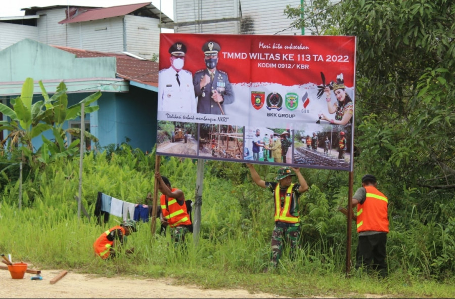 Anggota satgas saat memasang berbagai spanduk dalam kegiatan TMMD ke-113 tahun 2022 di beberapa titik di Kampung Kelian. (Foto: Kodim 0912/KBR)