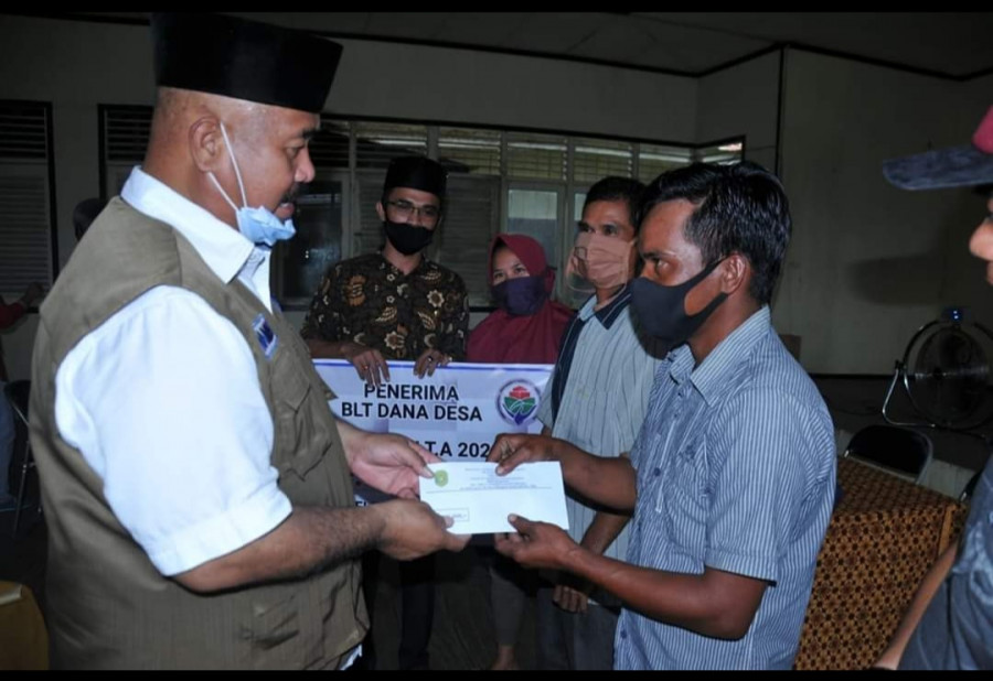 Bupati Kutai Kartanegara, Edi Damansyah saat menyerahkan BLT DD kepada warga Sebulu. (Foto:IST)