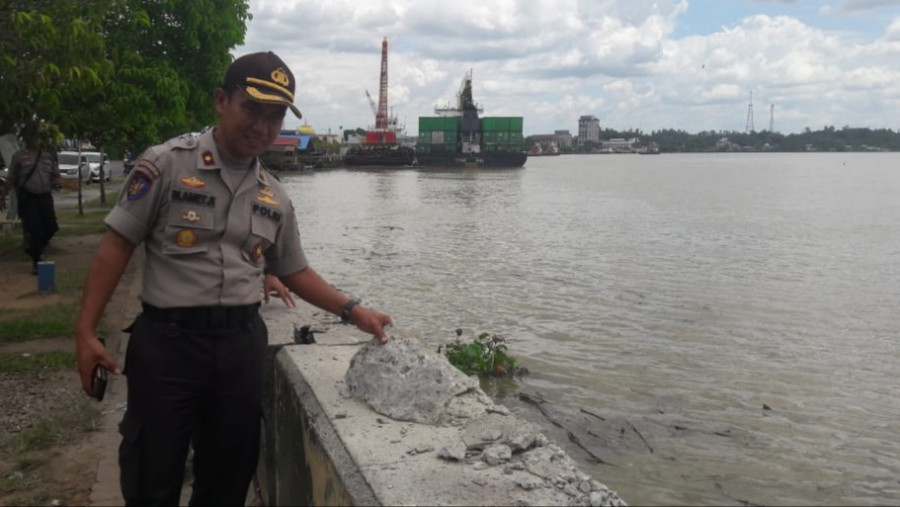 Pihak kepolisian yang menunjuk kerusakan turap sungai segah