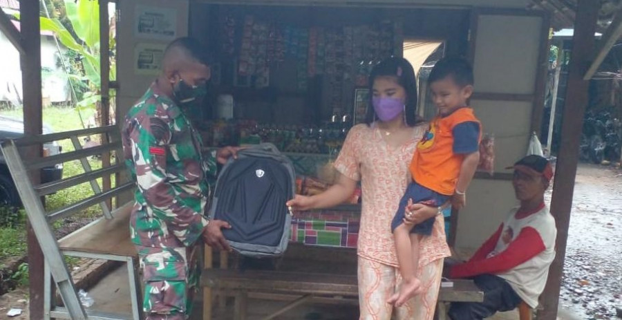 Perwakilan Satgas TMMD saat memberikan hadiah tas sekolah kepada Najmi, seorang anak penyandang disabilitas. (Foto: Pendam VI/Mlw)