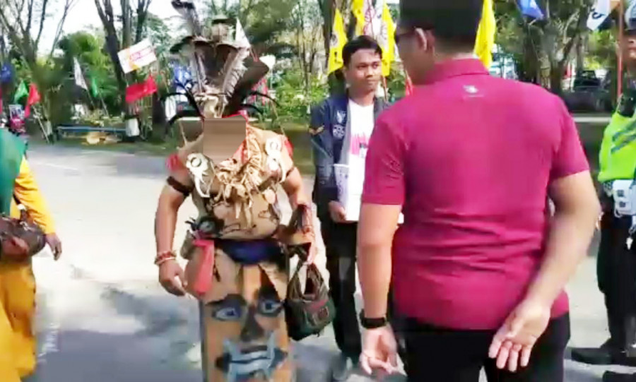 Seorang peserta kampanye berpakaian adat kedapatan membawa mandau saat hendak memasuki arena kampanye Capres RI 01 Joko Widodo di Balikpapan. (Hendra/KoranKaltim.Com)