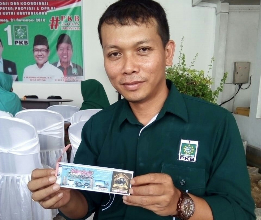 Ketua DPC PKB Kukar Pudji Hartadi menunjukkan satu bundel tiket jalan santai Koran Kaltim.
