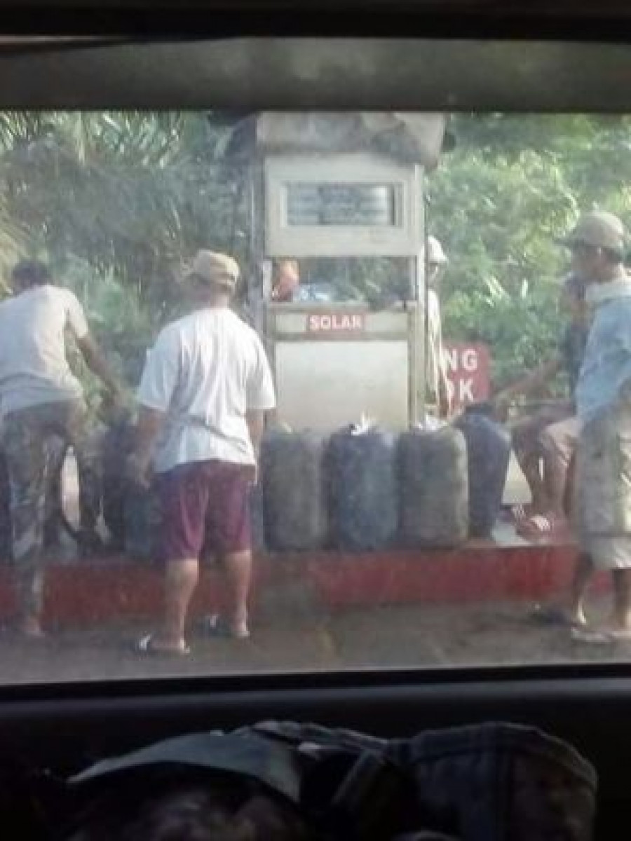 Pakai jirigen Petugas salah satu PSBU ini sedang menjual BBM jenis solar kepada warga yang menggunakan jerigen