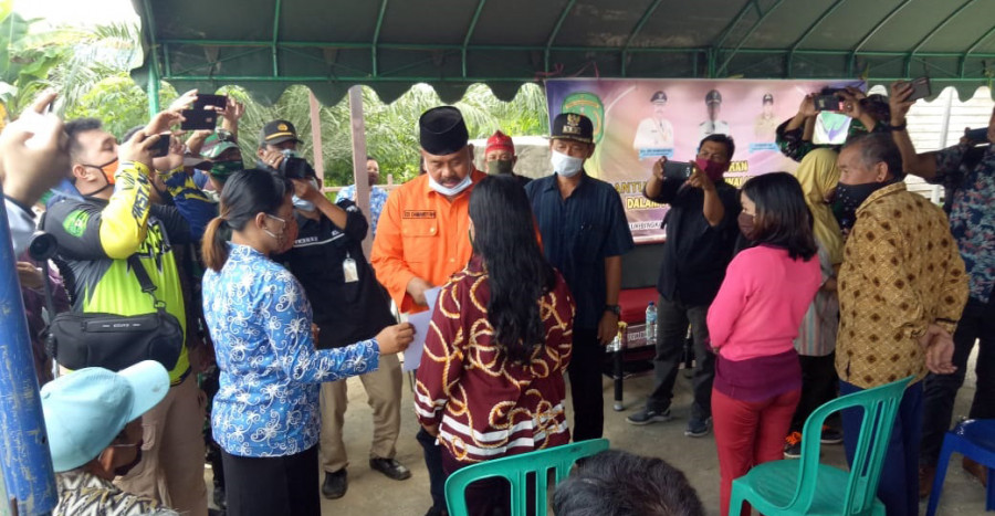 Camat Kenohan, Lukman Budiyono (Baju biru) saat mendampingi Bupati Kukar, Edi Damansyah dalam penyaluran BLT DD (Foto: Ist/Camat Kenohan)
