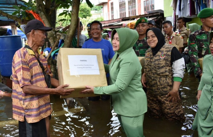 Ketua Persit KCK Yonif 611, Ny Arfan Affandi saat memberikan bantuan langsung kepada korban banjir di daerah Sungai Pinang Sabtu (15/6) tadi.( Foto: IST)