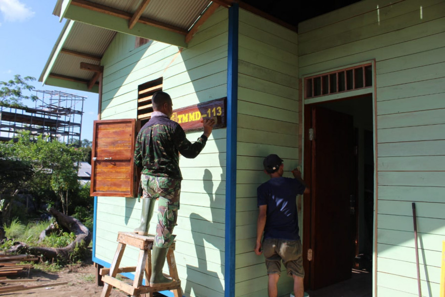 Anggota satgas TMMD mulai melakukan pengecatan rumah/mess guru SDN 015 Kelian. (Foto: Kodim 0912/KBR)