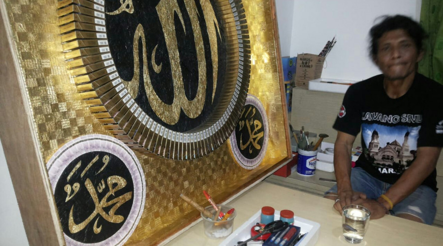 Burhanuddin Afif bersama kaligrafi hasil karyanya yang akan dilelang. Hasil lelang itu 100 persen akan disumbangkan demi membiayai tunggakan dua anak yang mejadi pasien di RSKD. (Hendra/KoranKaltim.Com)