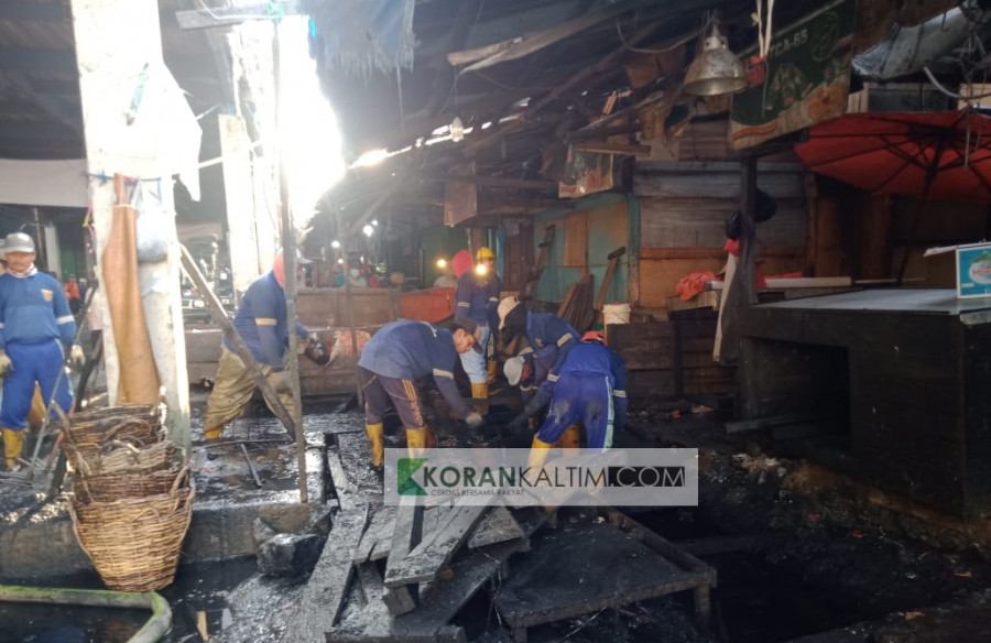 Tim pembersihan melakukan pengerukan sedimentasi pada drainase pasar (Claudius Vico/Korankaltim.com)