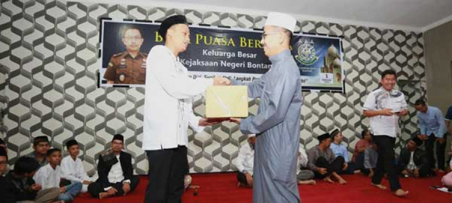 BINGKISAN Kajari Bontang Agus Kurniawan menyerahkan bingkisan kepada salah seorang anak yatim yang hadir pada acara buka puasa bersama.