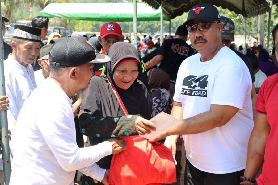 Bupati Kukar Edi Damansyah menyerahkan bantuan saat bakti sosial off road Kukar. (Foto: Prokom)