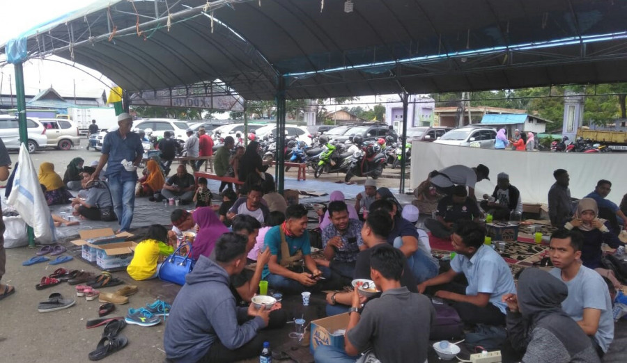 Tampak para jamaah haul guru sekumpul sedang menikmati hidangan gratis di kuaro ( dwi / korankaltim.com)
