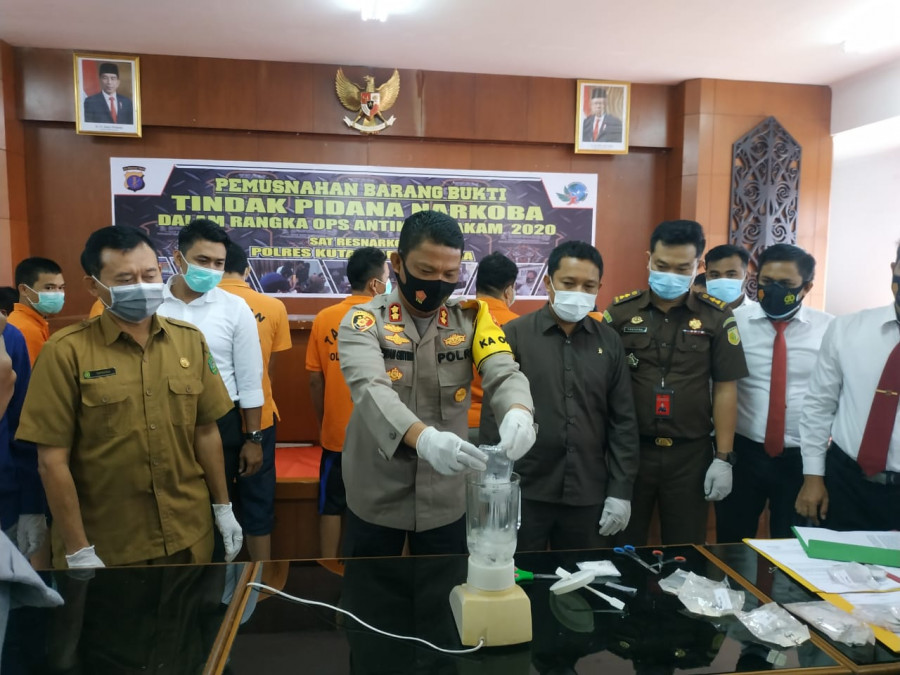 Kapolres Kukar, Irwan Masulin Ginting saat memasukan barang bukti sabu didalam belender. Foto:sabri/korankaltim.com)