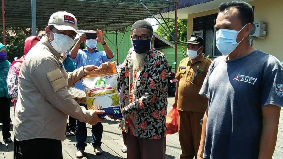 Sekda Kukar Sunggono secara simbolis menyerahkan bantuan kepada warga terdampak di Kecamatan Muara Muntai (Foto: HMS)