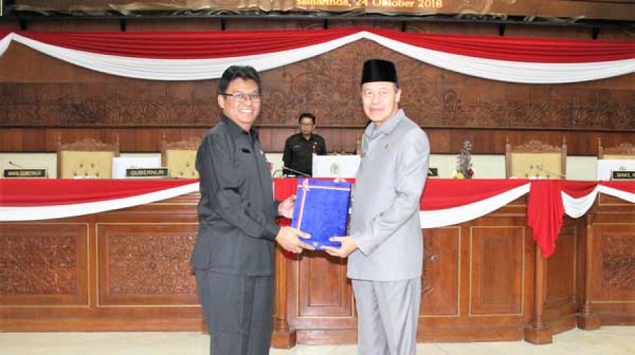 PENYERAHAN : Ketua DPRD Kaltim, HM Syahrun (kanan) saat menerima buku LKPj lima tahun masa jabatan Gubernur Kaltim periode 2013-2018 yang diserahkan langsung Asisten I Pemprov Kaltim, Sa’bani, Rabu (24/10) kemarin.
