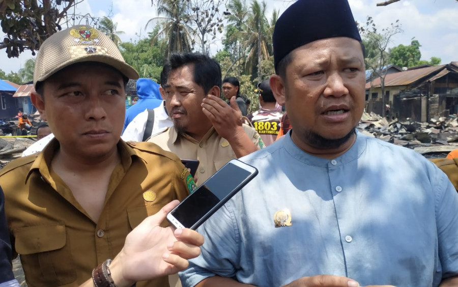 Ketua DPRD Kukar, Abdul Rasid didampingi Kepala Desa Loa Kulu Kota, Mohamad Rizali ditemui di lokasi kebakaran. (Foto:sabri/korankaltimcom)