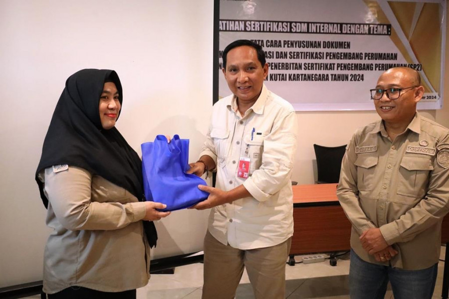 Asisten II Pemkab KUkar Ahyani Fadianur Diani membuka Pelatihan Sertifikasi Internal Ditandai penyerahan bahan ajar kepada perwakilan peserta pelatihan. (Foto: Prokom)