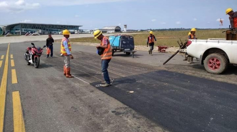Sejumlah pekerja memperbaiki taxiway yang amblas, kemarin ( ist)