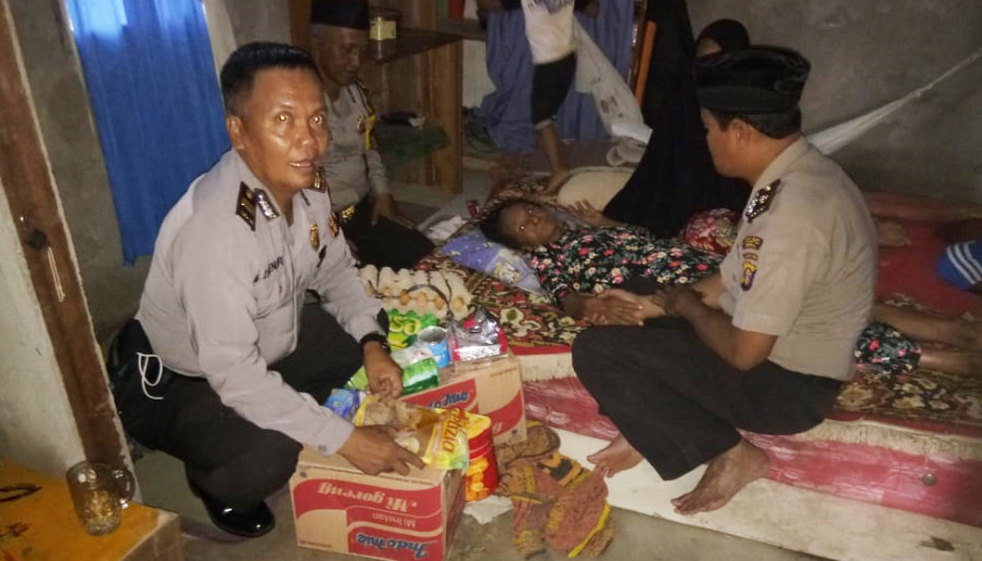 Kabag Sumda Polres Berau, Kompol Sumarji (berkopiah) berbincang dengan Misijah yang terbaring karena sakit. (Indra/KoranKaltim.Com)