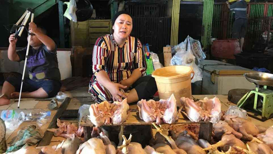 Pedagang daging ayam Eta Wati sedang berjualan di pasar pagi. (Foto: Muhibar Sobary A/ pusaranmedia.com)