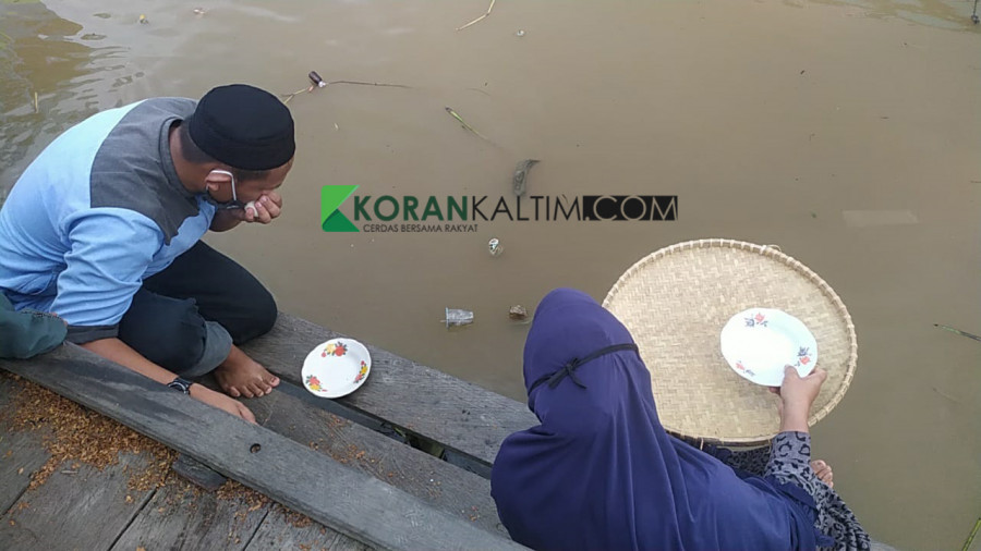 Pihak keluarga saat memberikan sesajen ke Sungai Mahakam, berharap dua orang tenggelam segera ditemukan Rabu (10/2/2021) hari ini. (Foto: Nancy/korankaltim.com)