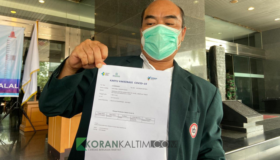 Ketua IDI Kaltim, Nathaniel Tandirogang saat menunjukkan surat vaksin (Foto: Permata/korankaltim.com)