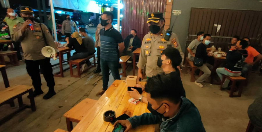 Kapolsek Sungai Kunjang Kompol Made Anwara saat memberikan imbauan salah satu pengunjung di kafe Sabtu (22/1/2022) tadi malam. (Foto: Humas Polsek Sungai Kunjang)